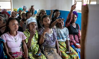 DRC - women in classroom raising hands