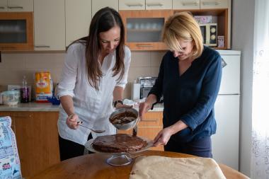 Brita and Amela standing together and mixing batter for a cake; Photo: Hazel Thompson