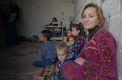 smiling displaced woman and family in KRI